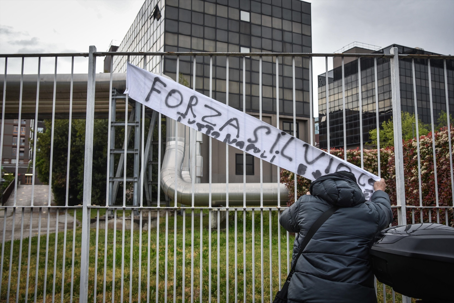 Un simpatizante del ex primer ministro de Italia Silvio Berlusconi coloca una pancarta en la que pone