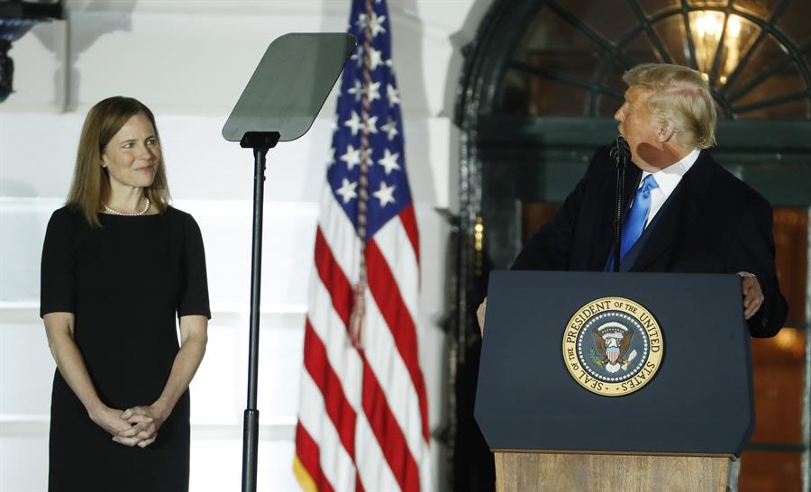 Amy Coney Barrett, durante la ceremonia de toma de posesion de su cargo como nueva jueza del Tribunal Supremo de EE UU, junto al presidente estadounidense, Donald Trump, en la Casa Blanca.