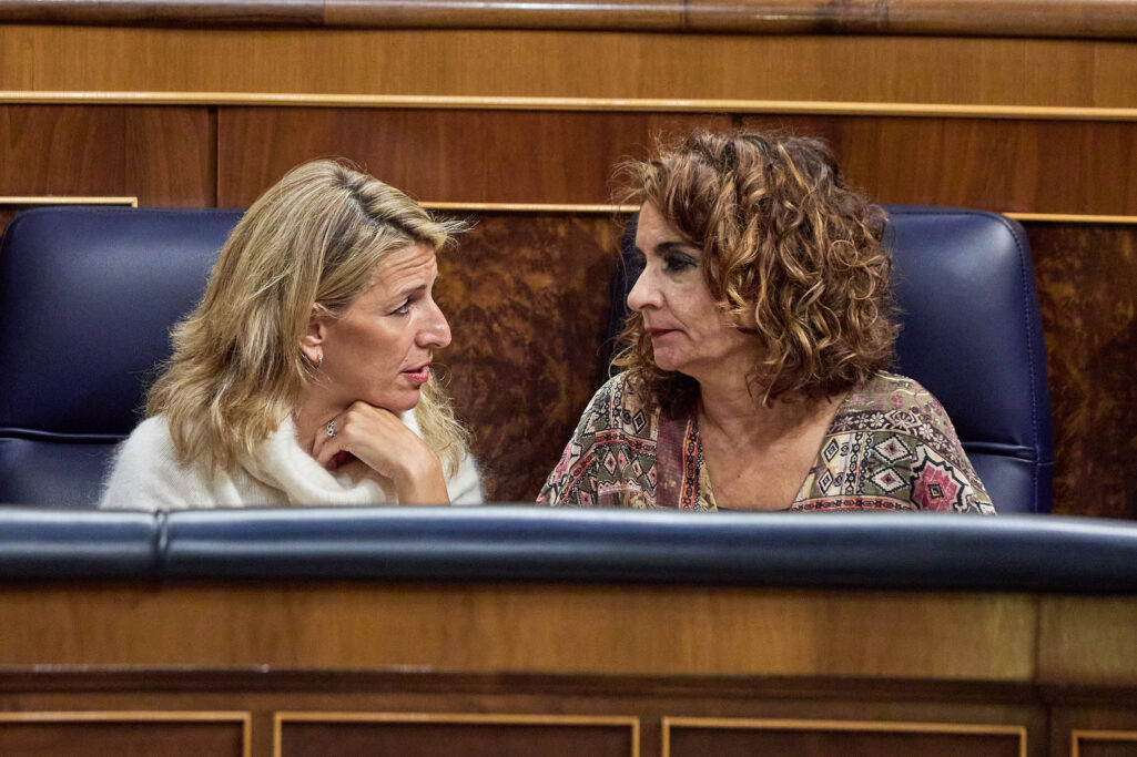 Yolanda Diaz y Maria Jesus Montero conversan durante una sesion plenaria en el Congreso.