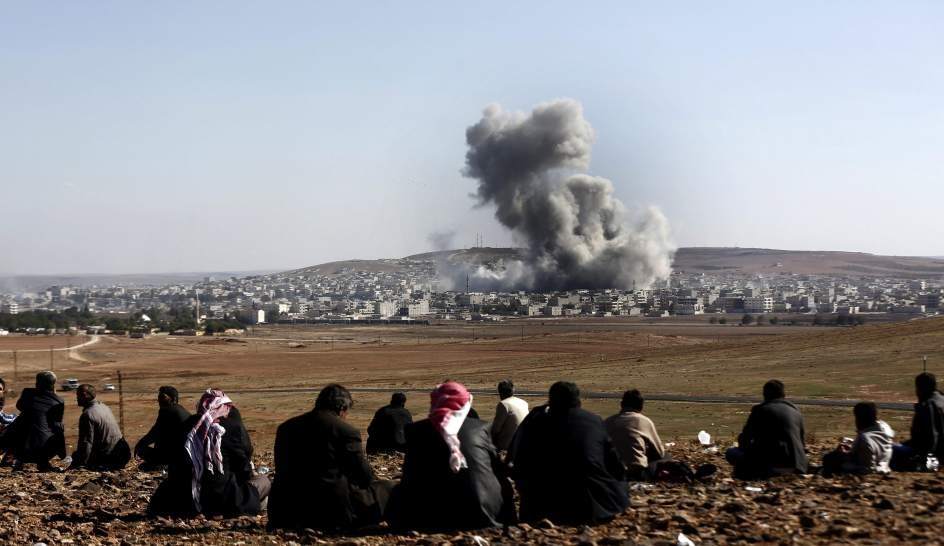 El asedio de las milicias de Estado Islamico (EI) a la ciudad kurdo siria de Kobani (cercana a la frontera con Turquia) provoco el desplazamiento de miles de kurdos hacia Turquia. Mientras, una coalicion internacional liderada por EEUU bombardeaba enclaves estrategicos de EI en Irak y Siria. En la imagen, la ciudad de Kobani, durante los combates entre fuerzas de EI y combatientes kurdos.