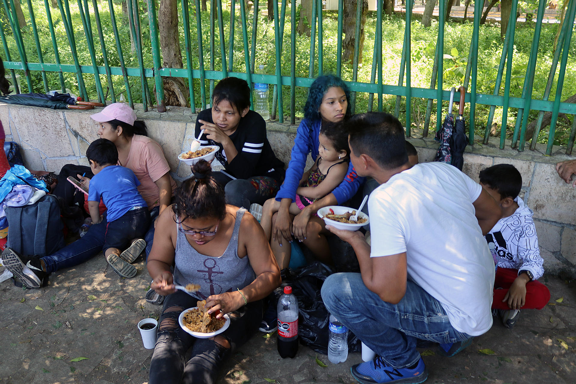 Migrantes comparten alimentos en un campamento, en Tapachula, Chiapas (Mexico).