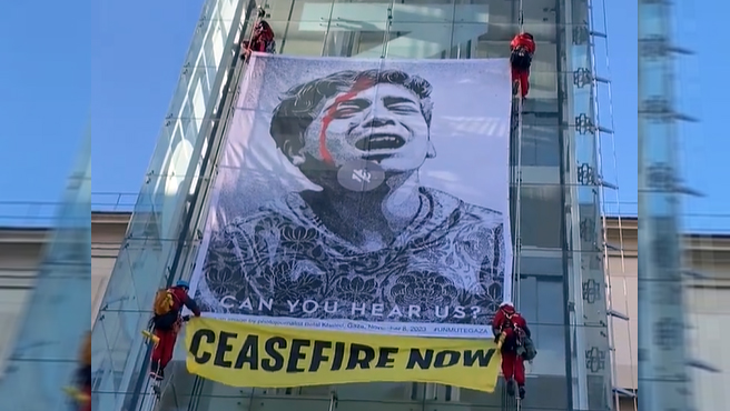 Varios activistas de Greenpeace han escalado una de las torres acristaladas del museo Reina Sofia, en Madrid, para desplegar una ilustracion de casi 60 metros cuadrados, obra del artista Shepard Fairey, conocido como OBEY, para pedir el alto el fuego en Gaza.