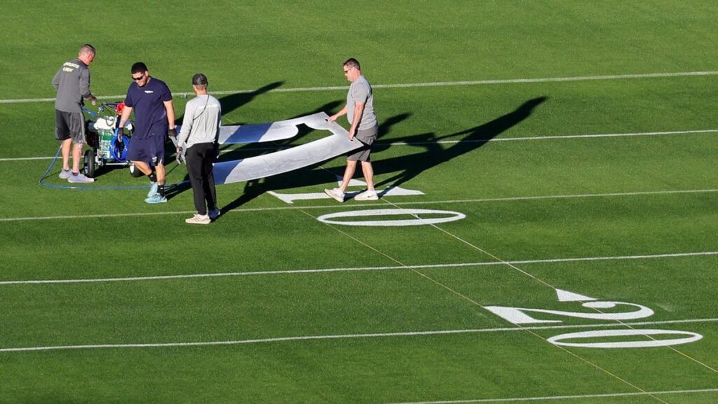 Operarios pintan las lineas del terreno de juego del Allegiant Stadium de Las Vegas.