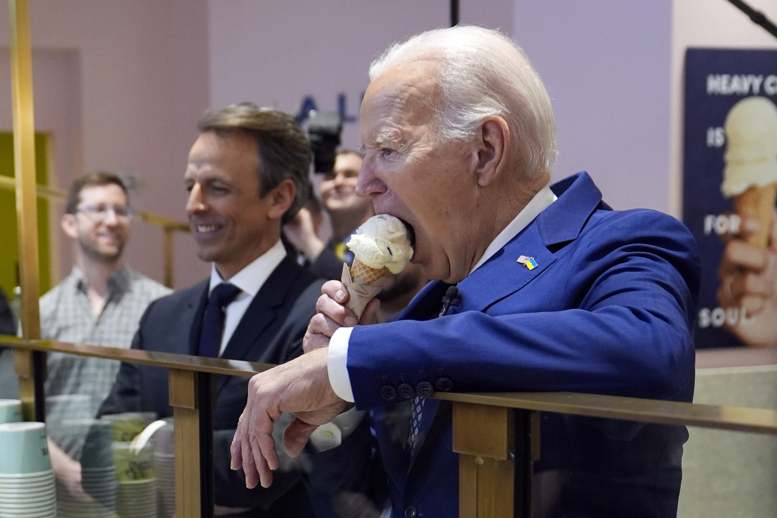 El presidente Joe Biden come helado en Van Leeuwen Ice Cream el lunes 26 de febrero de 2024, en Nueva York, mientras Seth Meyers observa.
